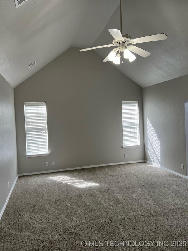 empty room with visible vents, a ceiling fan, lofted ceiling, and carpet flooring