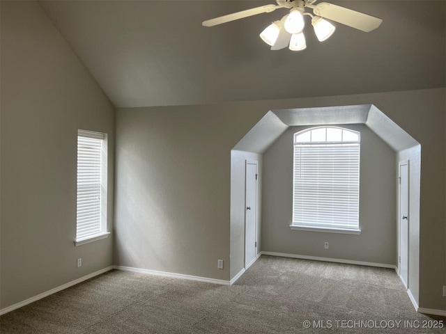 additional living space with baseboards, a ceiling fan, carpet, and lofted ceiling