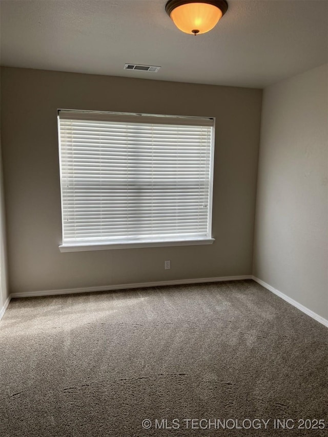 carpeted empty room with baseboards and visible vents