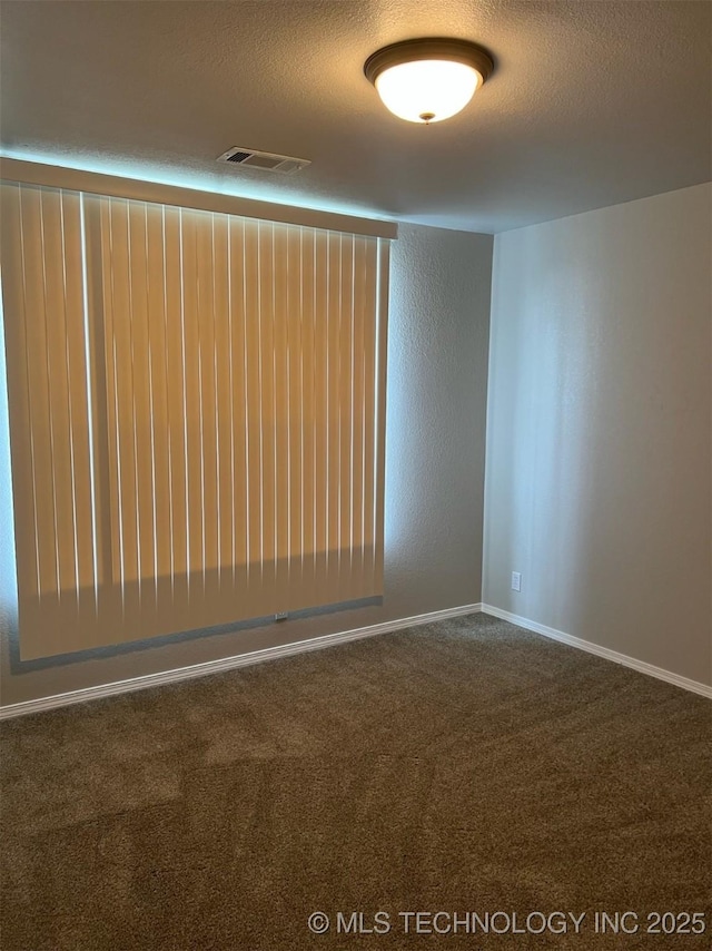 empty room with a textured ceiling, visible vents, baseboards, and carpet