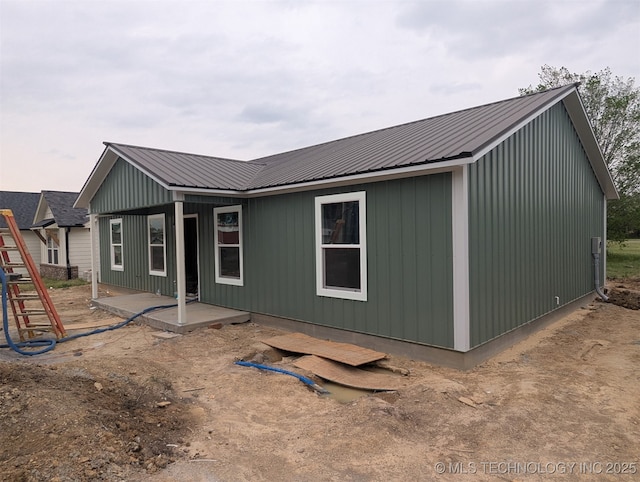 back of property featuring a patio and metal roof