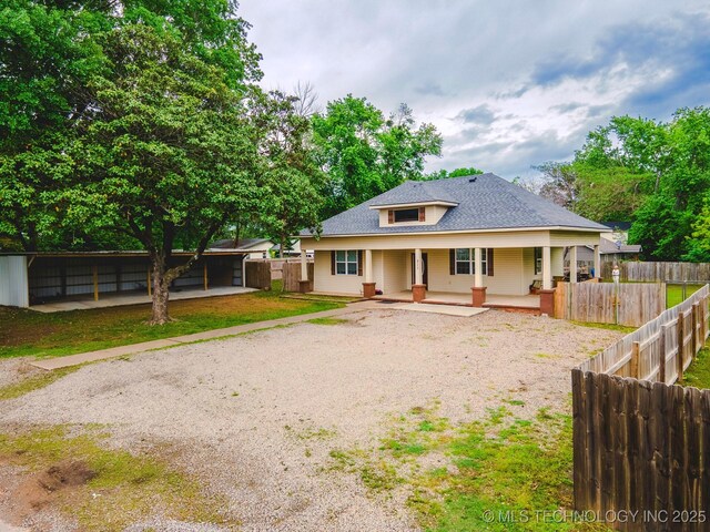 711 W Denton Ave, Sallisaw, OK 74955 - rear view of property with a porch, driveway, and a shingled roof