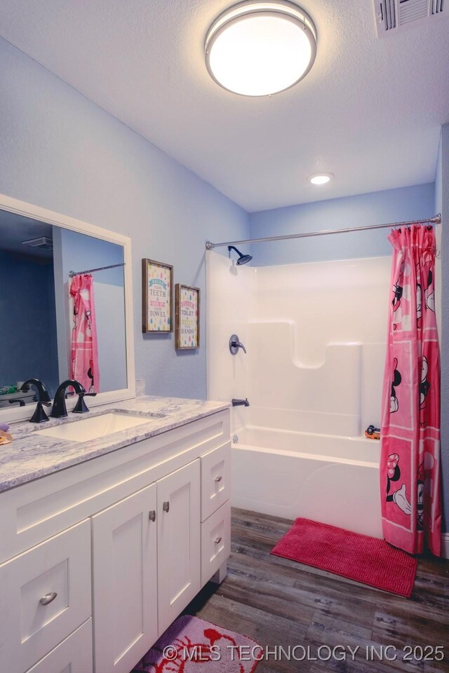 711 W Denton Ave, Sallisaw, OK 74955 - bathroom with a textured ceiling, visible vents, wood finished floors, vanity, and shower / bathtub combination with curtain