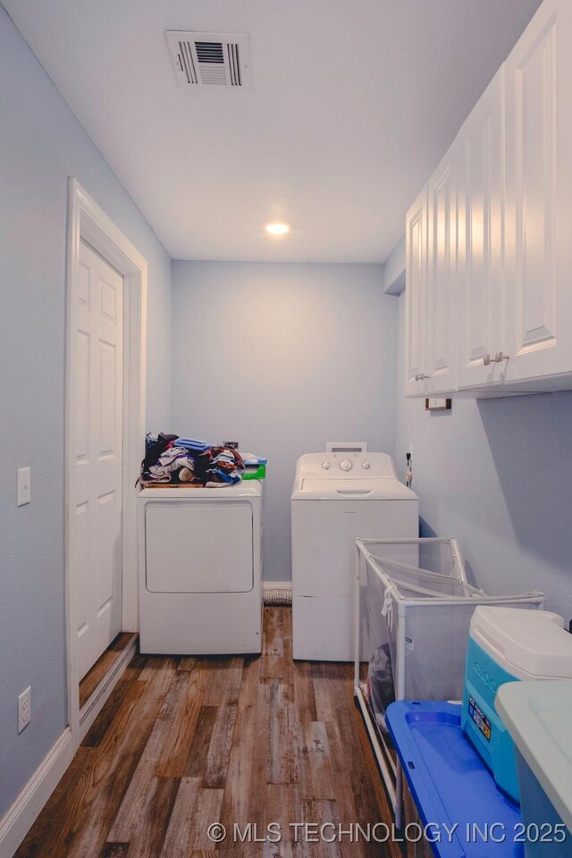 711 W Denton Ave, Sallisaw, OK 74955 - clothes washing area featuring washer and dryer, cabinet space, wood finished floors, and visible vents