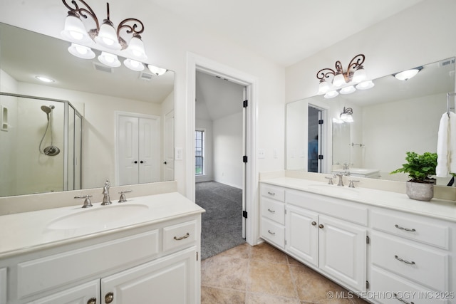 full bath featuring two vanities, a stall shower, and tile patterned floors