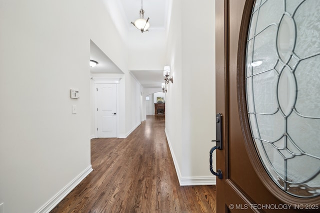 entrance foyer with dark wood-style flooring and baseboards