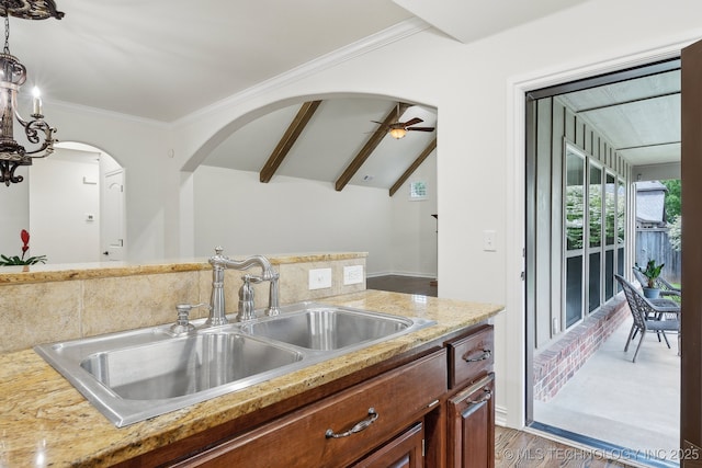 kitchen featuring a sink, crown molding, pendant lighting, ceiling fan, and wood finished floors