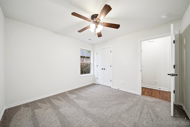 unfurnished bedroom featuring carpet, baseboards, a closet, and a ceiling fan