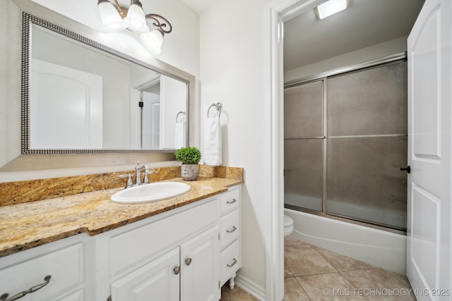 full bathroom featuring vanity, toilet, tile patterned flooring, and bath / shower combo with glass door