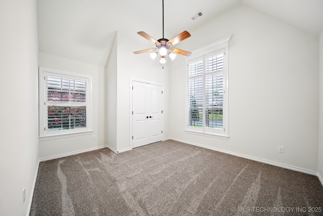 unfurnished bedroom featuring lofted ceiling, carpet, baseboards, and a ceiling fan