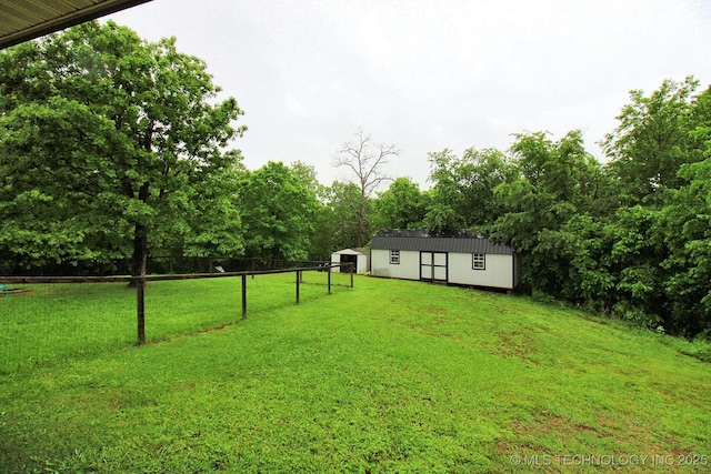 view of yard featuring fence, an outbuilding, and a storage unit
