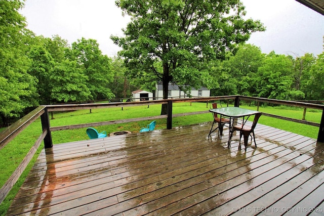 wooden deck with a yard and an outbuilding