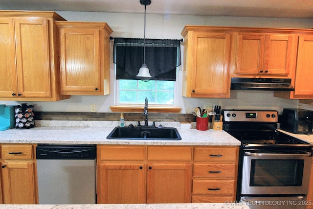 kitchen with a sink, appliances with stainless steel finishes, and under cabinet range hood