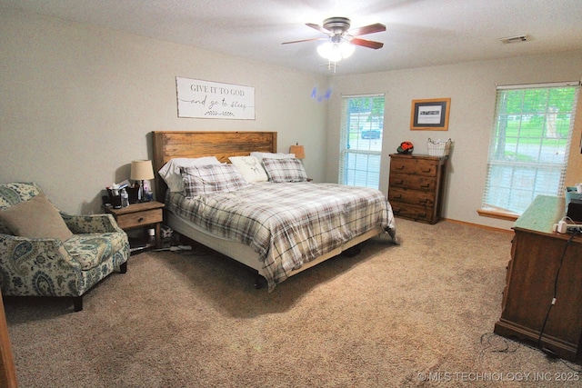 carpeted bedroom with visible vents and ceiling fan