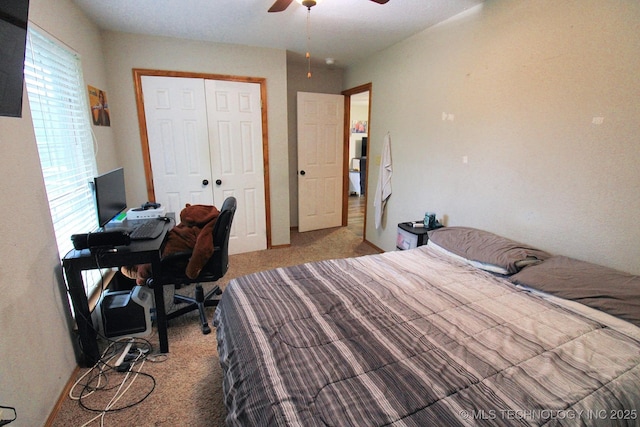 bedroom with ceiling fan, light carpet, and a closet