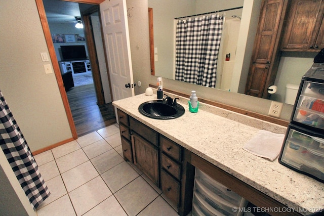 bathroom with tile patterned flooring, baseboards, a shower with curtain, and vanity