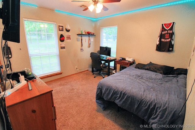 carpeted bedroom with a ceiling fan and visible vents