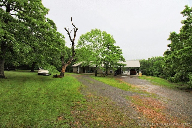 view of front facade featuring a front yard and dirt driveway