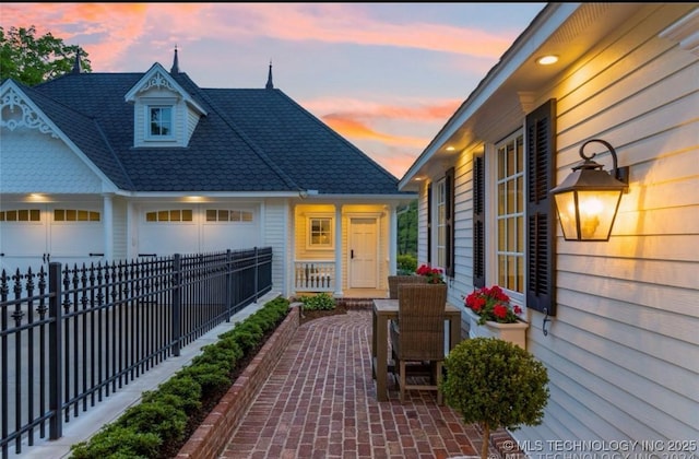 view of front of house with a patio, fence, and a garage