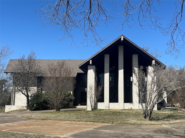 view of front of property featuring a front yard and brick siding
