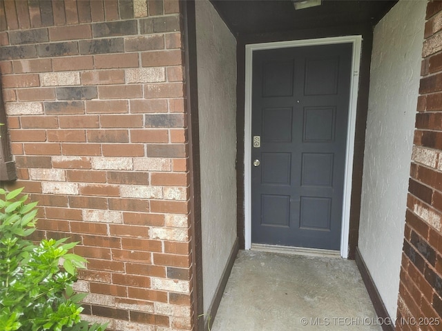 property entrance with brick siding