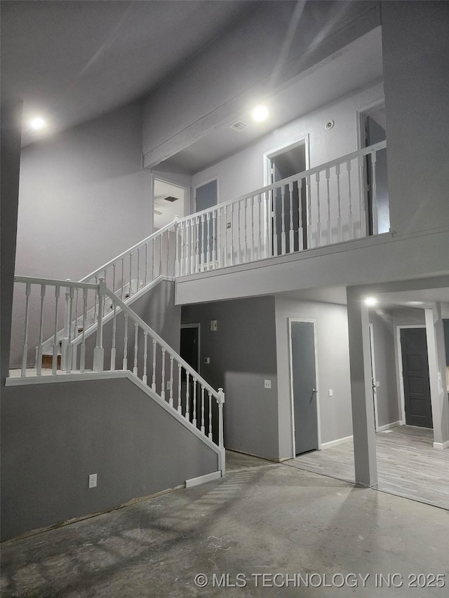 interior space with concrete floors and a towering ceiling