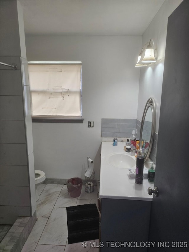 bathroom with vanity, toilet, and marble finish floor