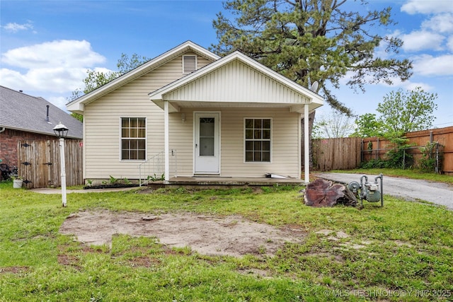 bungalow-style house featuring a porch, fence, and a front yard