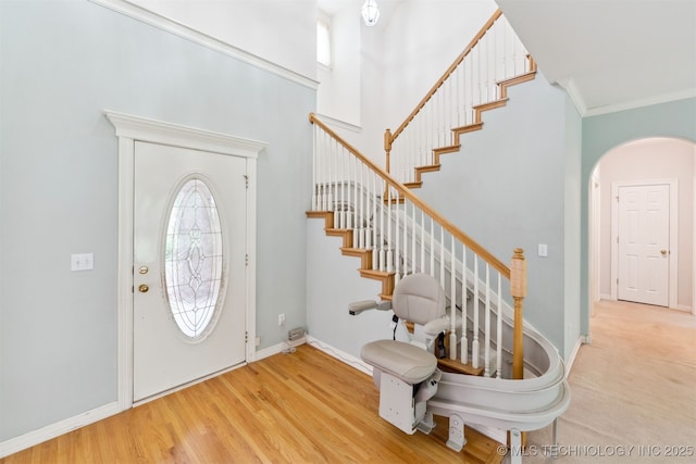 foyer entrance with stairway, baseboards, and ornamental molding