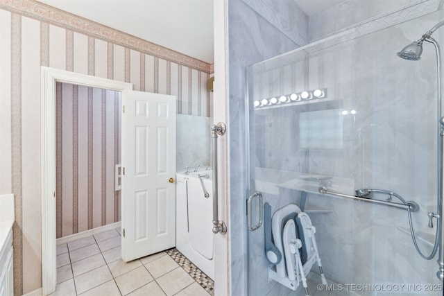 full bath with washer / dryer, tile patterned floors, a stall shower, and wallpapered walls