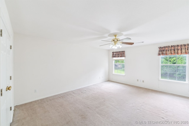 spare room featuring baseboards, a ceiling fan, and light colored carpet
