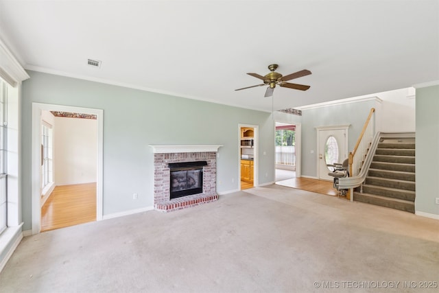 unfurnished living room with a ceiling fan, ornamental molding, and carpet