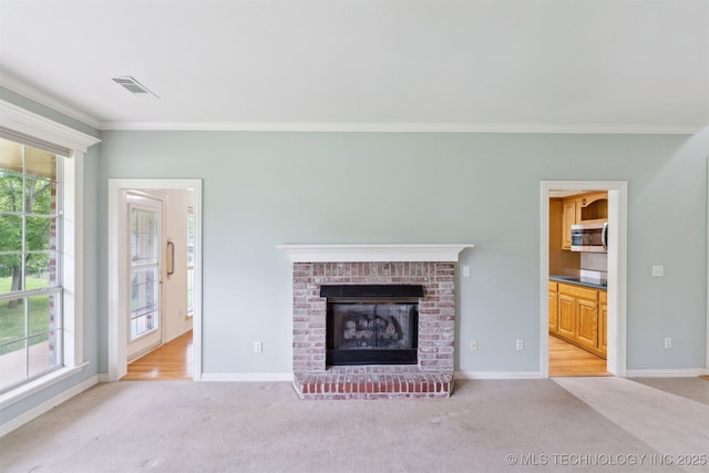 unfurnished living room with a wealth of natural light, ornamental molding, and light colored carpet