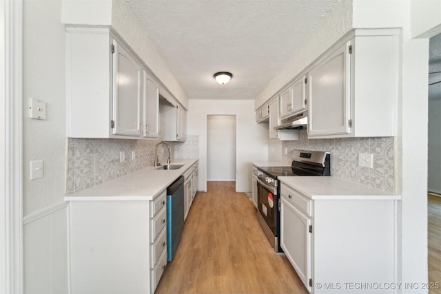 kitchen featuring a textured ceiling, tasteful backsplash, a sink, under cabinet range hood, and stainless steel appliances
