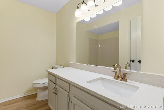 bathroom featuring vanity, baseboards, toilet, and wood finished floors