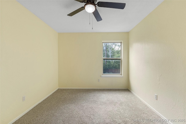 carpeted spare room with baseboards and ceiling fan