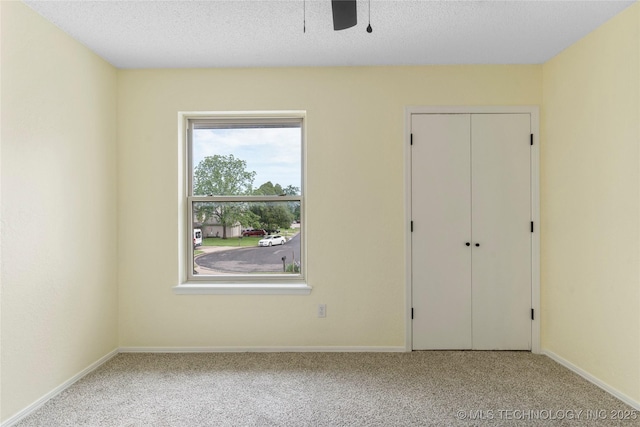 unfurnished bedroom featuring carpet floors, baseboards, a closet, and a textured ceiling