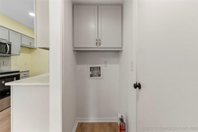 washroom with baseboards, laundry area, light wood finished floors, and washer hookup