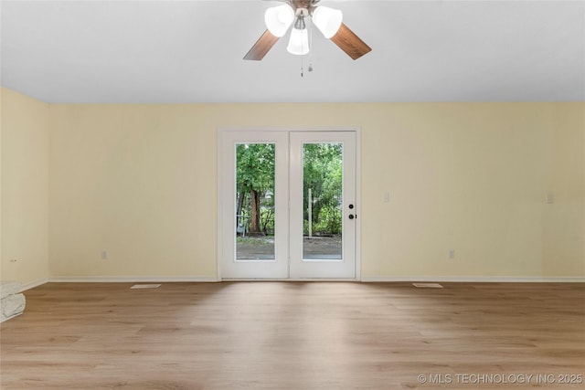 spare room featuring baseboards, light wood-style floors, ceiling fan, and visible vents