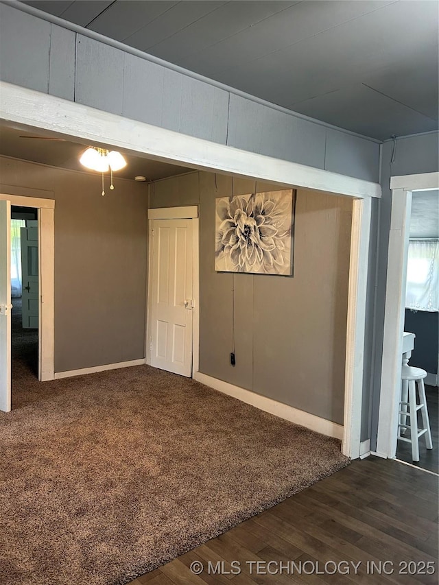 spare room featuring baseboards and wood finished floors