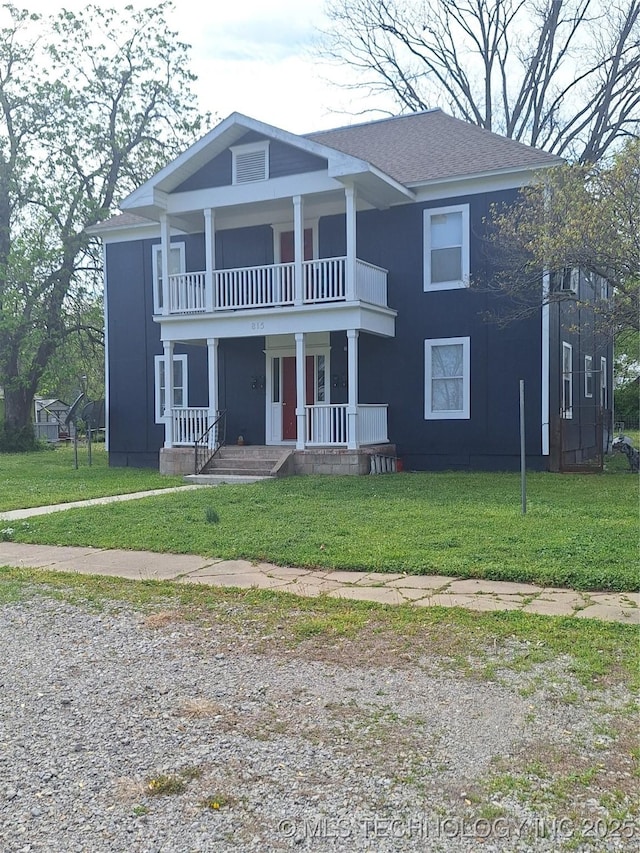 neoclassical / greek revival house featuring roof with shingles, covered porch, a front yard, and a balcony