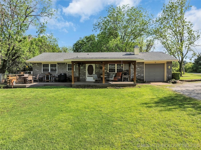 back of property with a lawn, dirt driveway, an attached garage, and a chimney