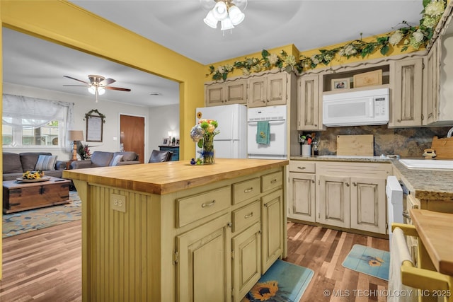 kitchen with a ceiling fan, a sink, light wood-style floors, white appliances, and butcher block countertops