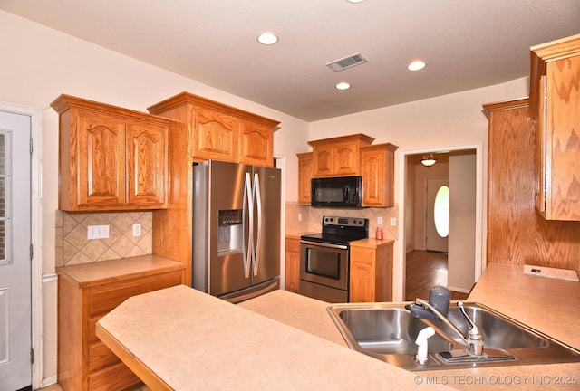 kitchen with visible vents, tasteful backsplash, a sink, stainless steel appliances, and recessed lighting