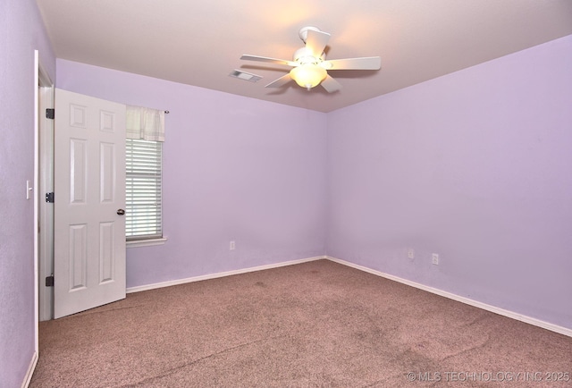carpeted empty room featuring visible vents, a ceiling fan, and baseboards