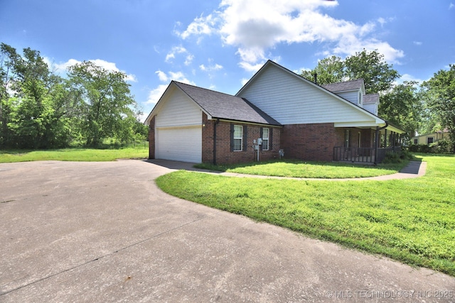 view of front of property featuring brick siding, a garage, and a front lawn