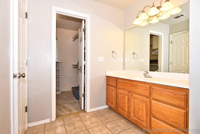 bathroom with visible vents, an inviting chandelier, vanity, baseboards, and tile patterned floors