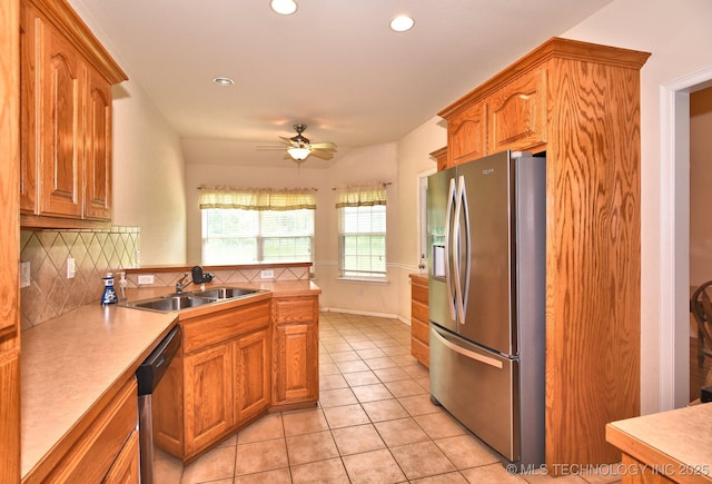 kitchen with a ceiling fan, tasteful backsplash, a sink, light tile patterned floors, and stainless steel appliances