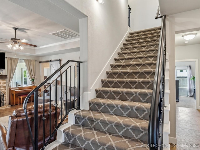 stairway with a ceiling fan and visible vents