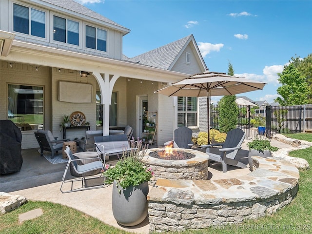 view of patio / terrace featuring fence and an outdoor living space with a fire pit